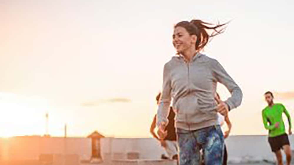 group of young people running in urban area at sunrise