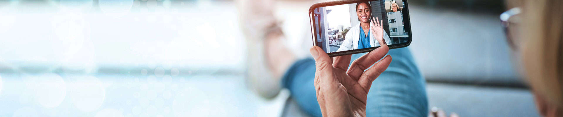 Hand holding a phone for a telehealth appointment