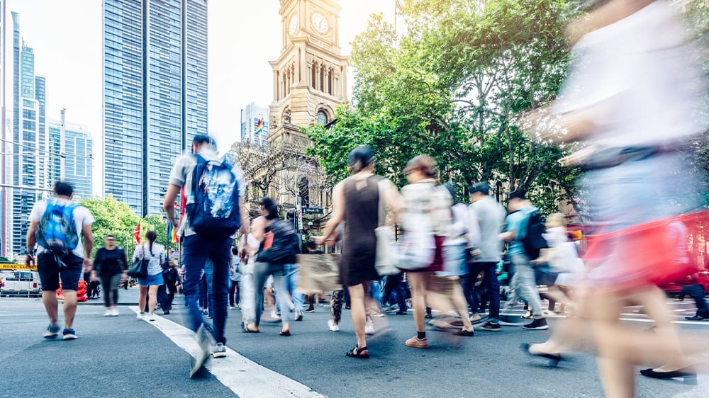 Back view of a crowd walking on a city street.