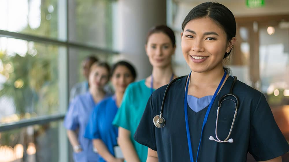 Health professional woman standing with other health professionals