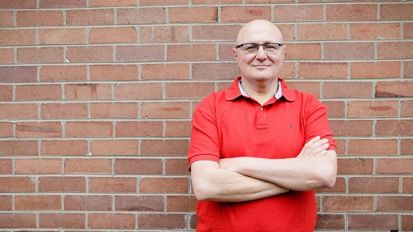 Joseph standing with arms folded