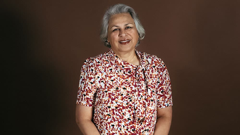 Rashmi standing with her hands together in front of her.