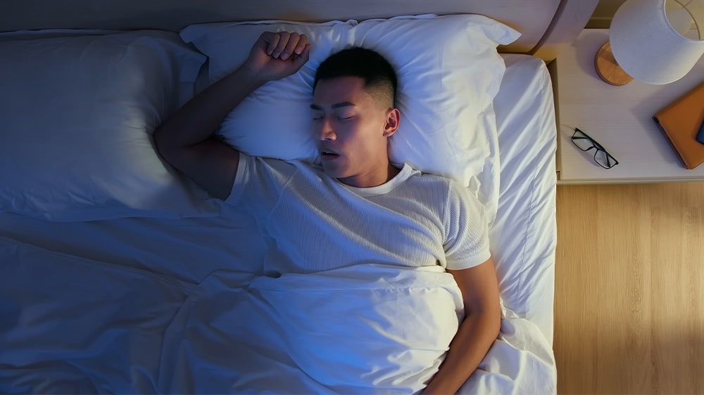 Young Asian man sleeping on his back