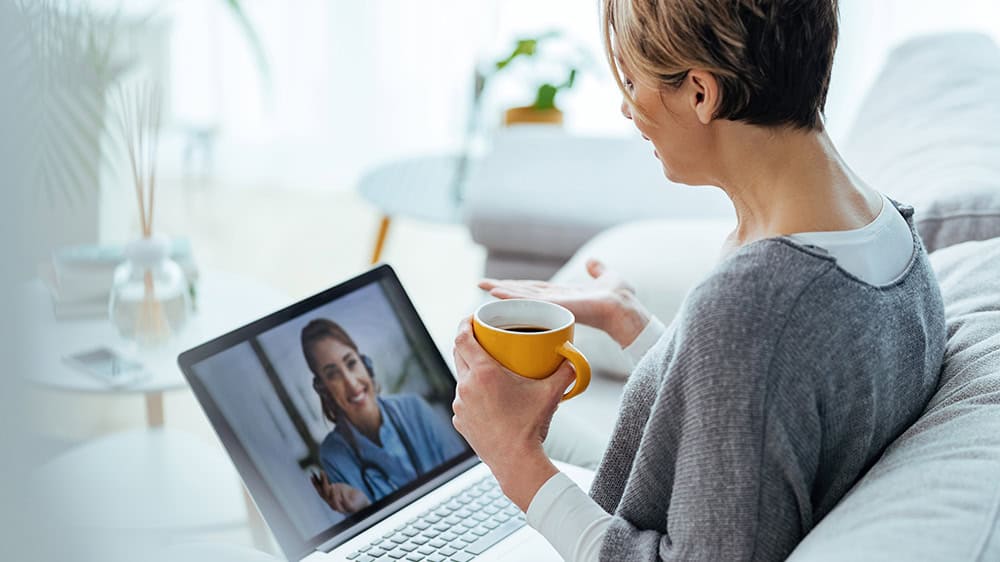 Woman in her home using her laptop for a diabetes telehealth appointment