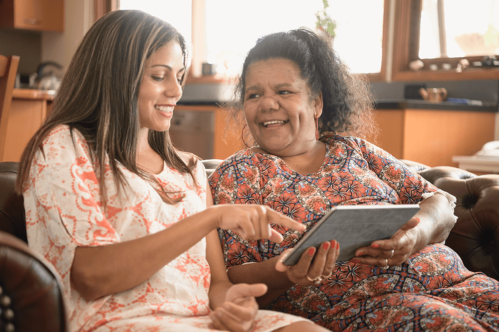 Two people looking up information online on a tablet